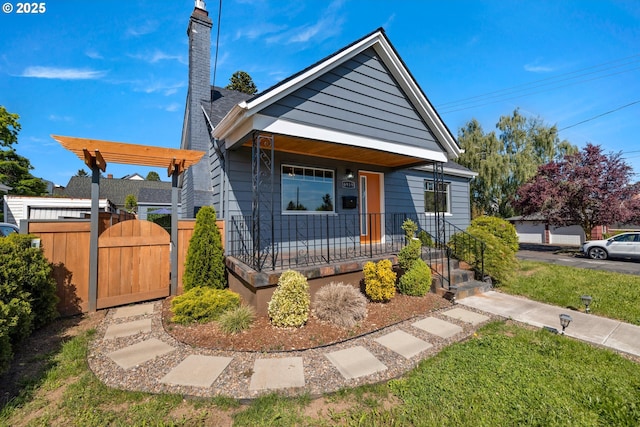 6959 N Denver Ave, Portland, OR 97217 - view of front facade with a porch, a gate, a chimney, and a front lawn
