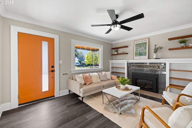 6959 N Denver Ave, Portland, OR 97217 - living room with dark wood-style flooring, a fireplace, ornamental molding, a ceiling fan, and baseboards