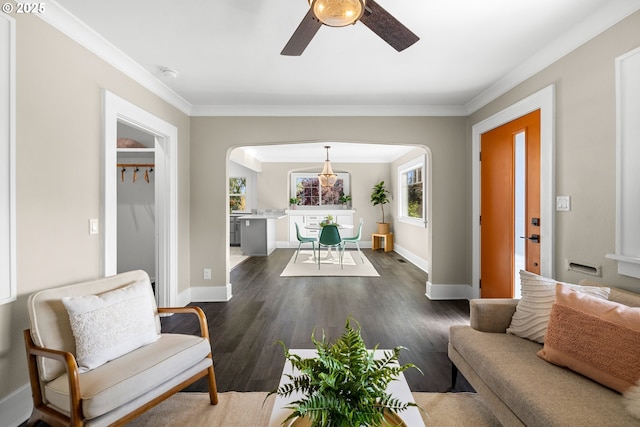 6959 N Denver Ave, Portland, OR 97217 - living room with arched walkways, ceiling fan, dark wood-style floors, crown molding, and baseboards