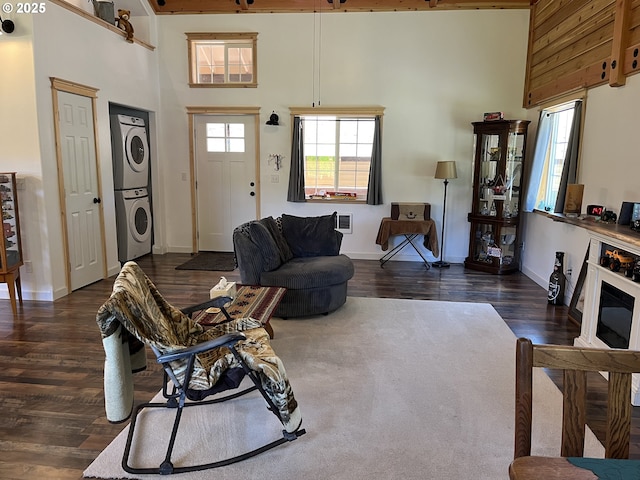 34376 State Highway 38, Scottsburg, OR 97473 - living room featuring stacked washer / dryer, a towering ceiling, dark wood-style floors, and baseboards