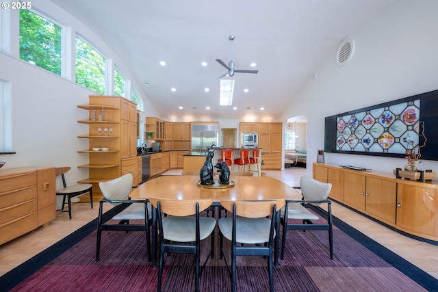 dining area featuring high vaulted ceiling, recessed lighting, a ceiling fan, light wood finished floors, and arched walkways