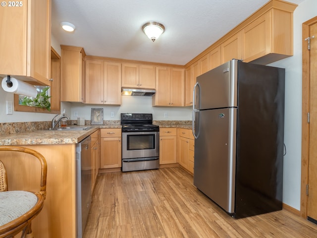 kitchen featuring light brown cabinetry, sink, light hardwood / wood-style flooring, stainless steel appliances, and light stone countertops