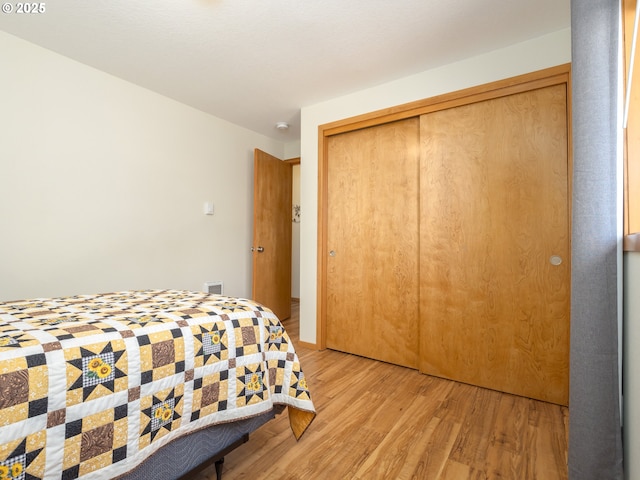 bedroom with light wood-type flooring and a closet