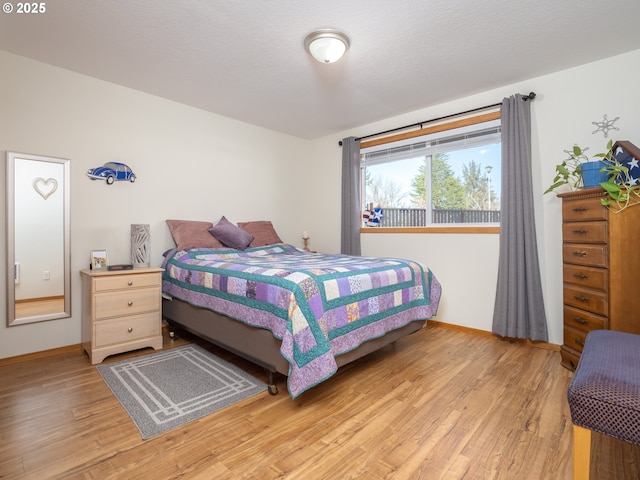 bedroom with a textured ceiling and light wood-type flooring