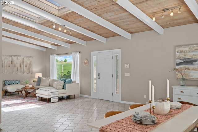 foyer featuring rail lighting, wood ceiling, baseboards, light tile patterned flooring, and a skylight