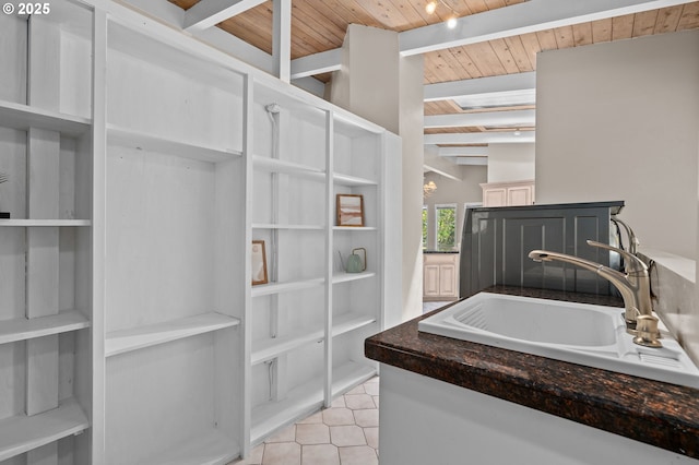 bathroom featuring wood ceiling, a sink, beamed ceiling, and tile patterned flooring
