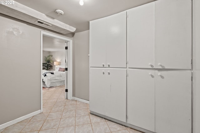 corridor featuring baseboards and light tile patterned floors