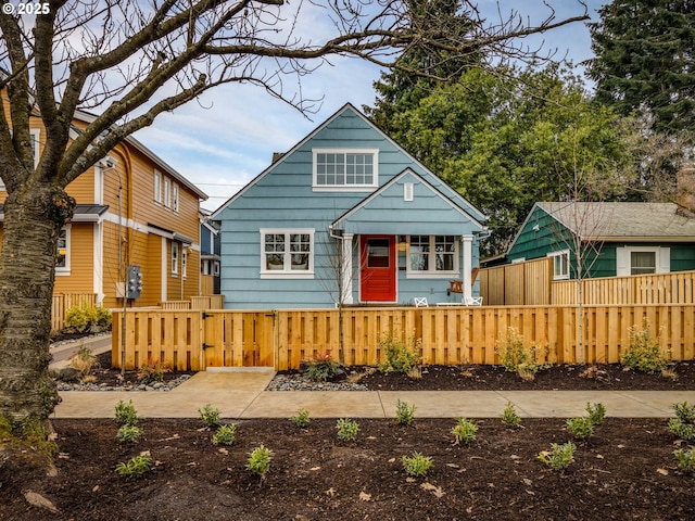 bungalow-style house with a fenced front yard and a gate