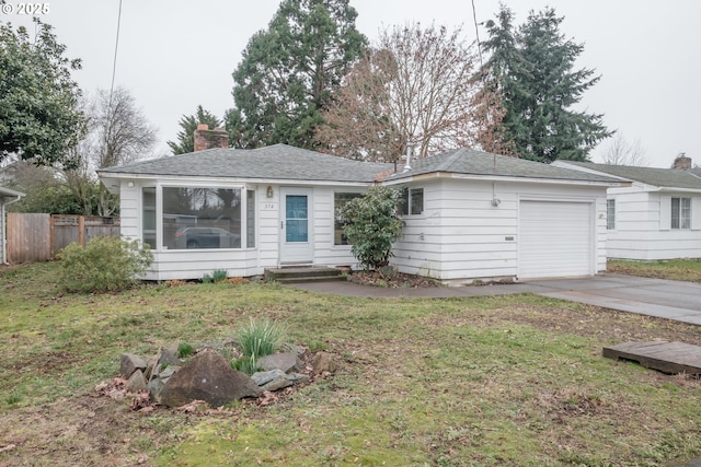 ranch-style house featuring driveway, a front lawn, an attached garage, and fence