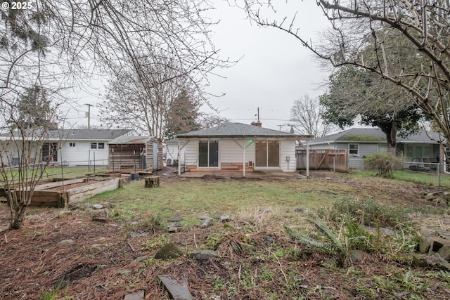 rear view of house featuring an outbuilding, fence, a garden, a storage unit, and a chimney