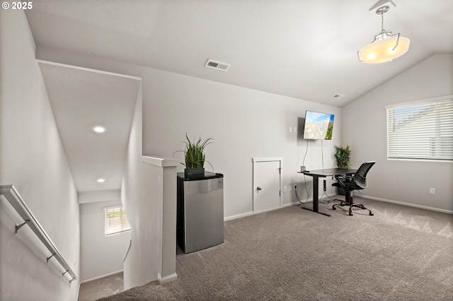 office featuring carpet floors, vaulted ceiling, visible vents, and baseboards