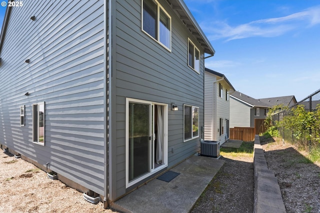 back of property with central AC and fence