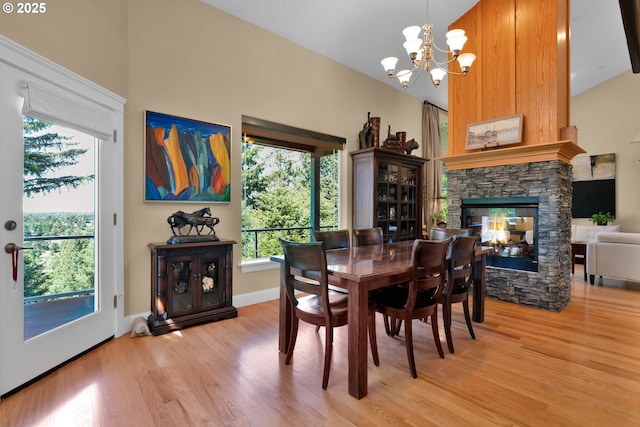 3563 Jake Mann Ln, Florence, OR 97439 - dining space featuring light wood-style flooring, a chandelier, a fireplace, and high vaulted ceiling