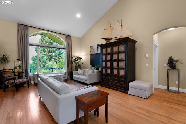 3563 Jake Mann Ln, Florence, OR 97439 - living area with high vaulted ceiling, arched walkways, light wood-style floors, and baseboards