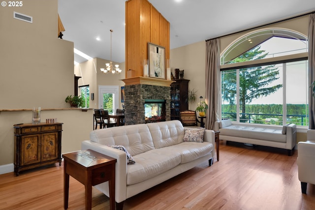 3563 Jake Mann Ln, Florence, OR 97439 - living area featuring high vaulted ceiling, light wood-style flooring, a chandelier, and a stone fireplace