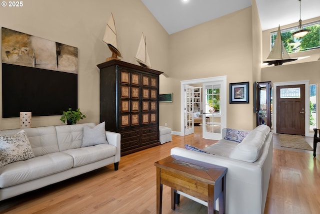 3563 Jake Mann Ln, Florence, OR 97439 - living room featuring a high ceiling, plenty of natural light, light wood-style floors, and baseboards