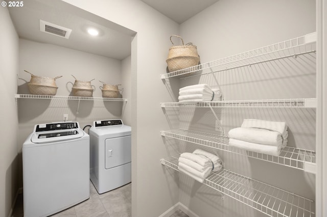 clothes washing area with light tile patterned flooring and independent washer and dryer