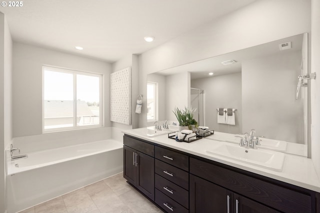 bathroom with vanity, a washtub, and tile patterned floors