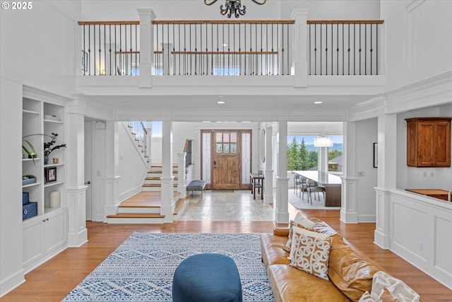 100 Garibaldi St, Lake Oswego, OR 97035 - entrance foyer with light wood-type flooring, stairway, a decorative wall, ornate columns, and a towering ceiling