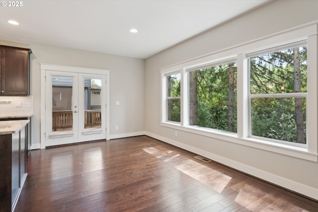 unfurnished dining area with recessed lighting, dark wood-style flooring, and baseboards