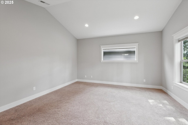 empty room featuring carpet floors, recessed lighting, vaulted ceiling, and baseboards