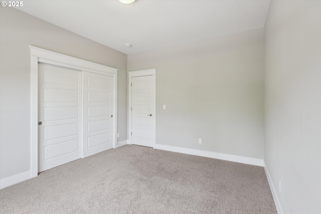 unfurnished bedroom with carpet, baseboards, and a closet
