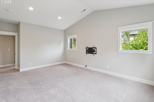 spare room featuring light carpet, baseboards, lofted ceiling, and recessed lighting