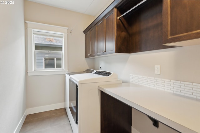 clothes washing area with cabinet space, independent washer and dryer, baseboards, and light tile patterned floors
