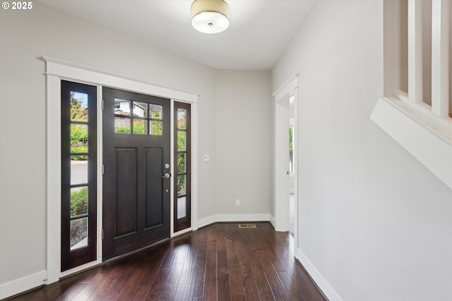 foyer entrance with dark wood finished floors and baseboards