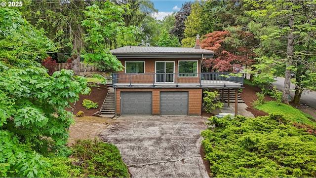 630 SW Viewmont Dr, Portland, OR 97225 - view of front facade with stairway, driveway, an attached garage, and metal roof