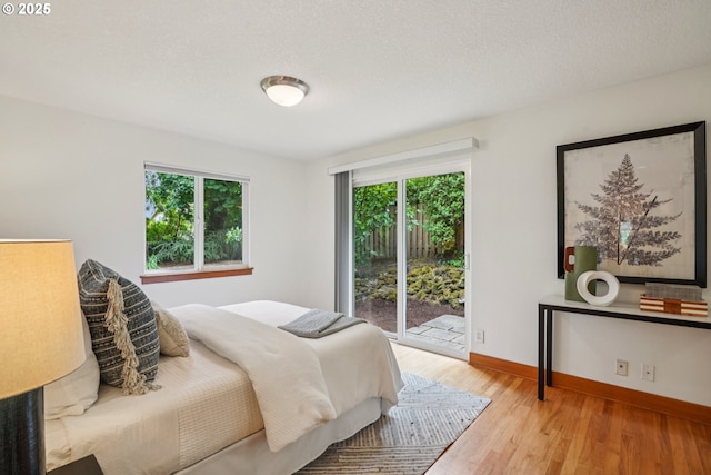 630 SW Viewmont Dr, Portland, OR 97225 - bedroom with access to outside, multiple windows, baseboards, and wood finished floors