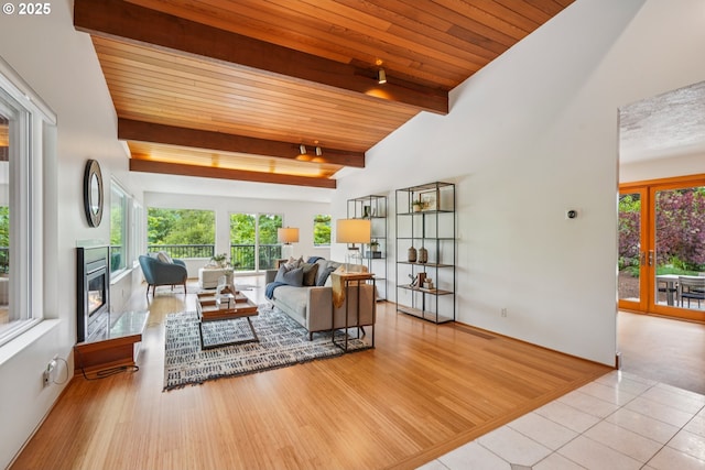 630 SW Viewmont Dr, Portland, OR 97225 - living area featuring healthy amount of natural light, wooden ceiling with exposed beams, a glass covered fireplace, french doors, and wood finished floors