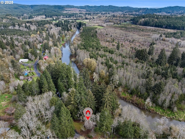 drone / aerial view featuring a wooded view and a water and mountain view