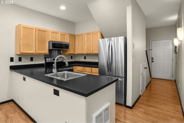 kitchen with appliances with stainless steel finishes, sink, light brown cabinetry, and kitchen peninsula