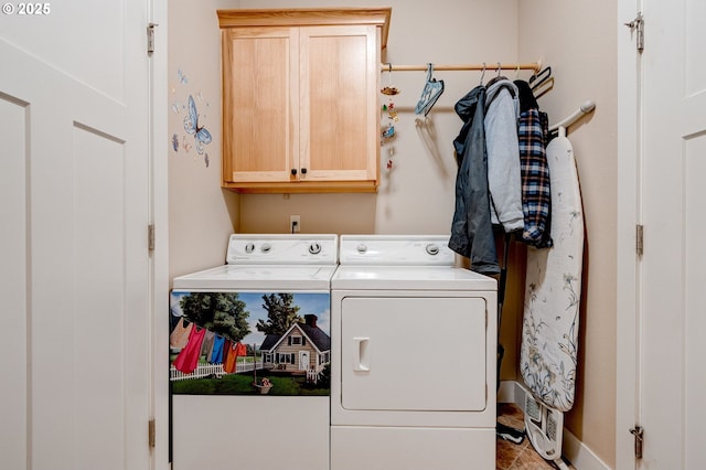 laundry area featuring washer and dryer, cabinet space, and baseboards