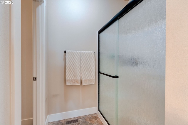 full bathroom with visible vents, a shower stall, and baseboards