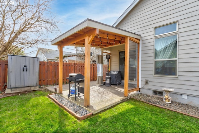 view of patio / terrace with an outbuilding, a shed, grilling area, and fence