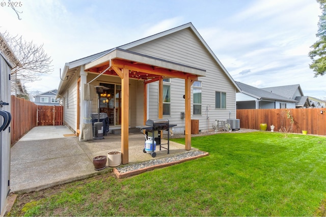 back of house featuring a patio area, a lawn, cooling unit, and a fenced backyard