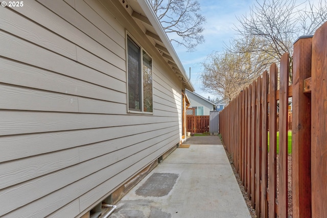 view of side of property featuring a patio and fence