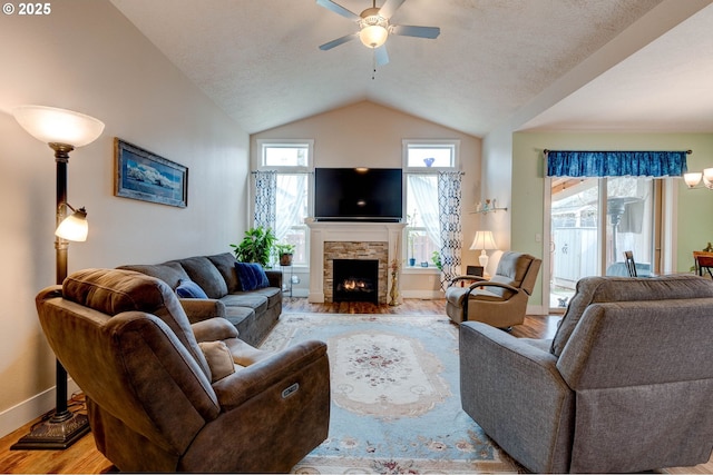 living room with a fireplace, lofted ceiling, plenty of natural light, and wood finished floors