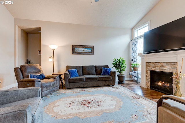 living room featuring a fireplace, vaulted ceiling, and wood finished floors