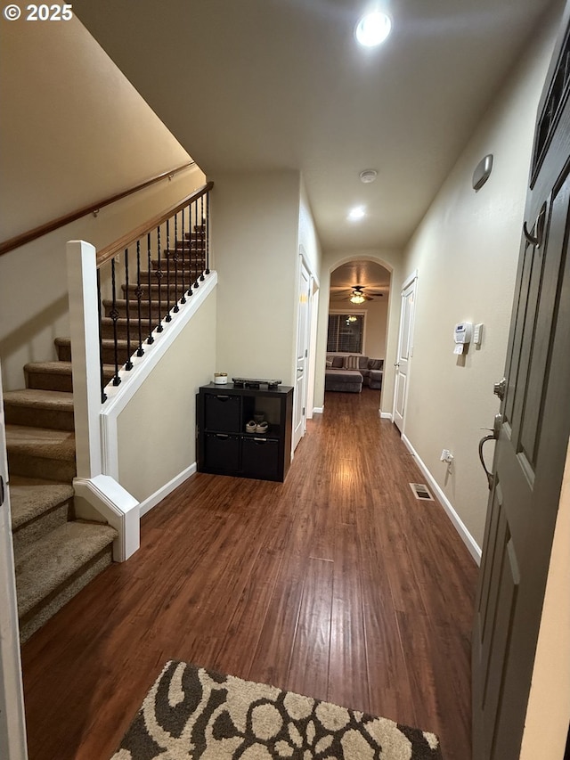 4002 N 3rd Cir, Ridgefield, WA 98642 - hallway featuring dark wood-style flooring, baseboards, stairs, recessed lighting, and arched walkways