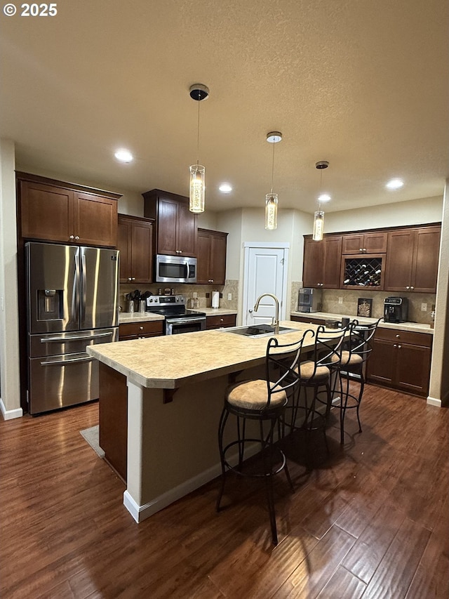 4002 N 3rd Cir, Ridgefield, WA 98642 - kitchen with appliances with stainless steel finishes, light countertops, dark wood-type flooring, dark brown cabinets, and recessed lighting