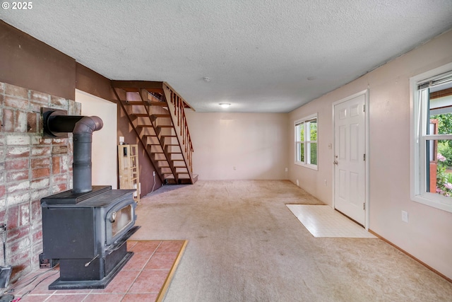 10303 SE Bull Run Rd, Corbett, OR 97019 - unfurnished living room featuring carpet floors, a wood stove, stairway, and a textured ceiling
