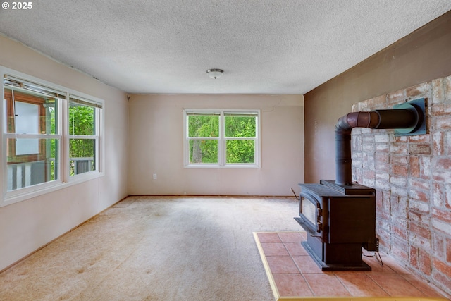 10303 SE Bull Run Rd, Corbett, OR 97019 - unfurnished living room featuring healthy amount of natural light, a wood stove, a textured ceiling, and carpet flooring