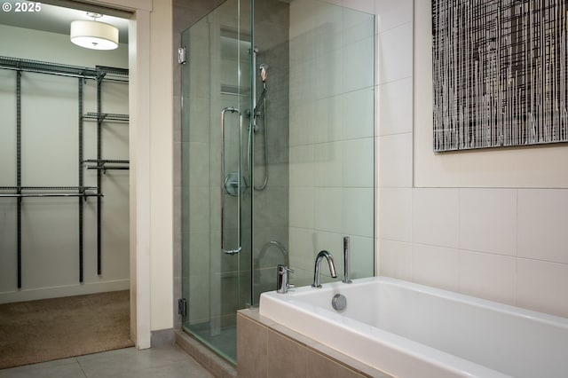 bathroom with tile patterned flooring and separate shower and tub