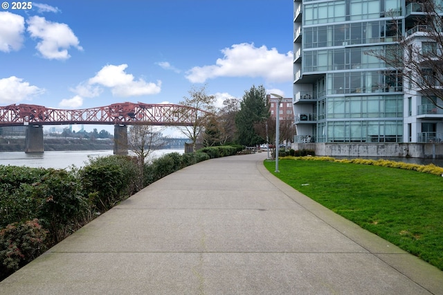 view of home's community featuring a water view and a lawn