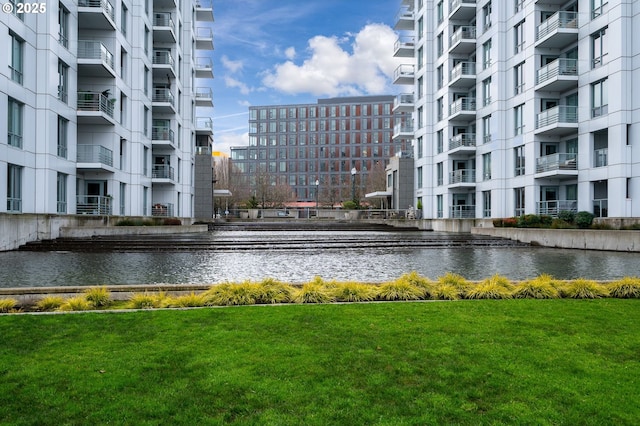 view of community with a lawn and a water view