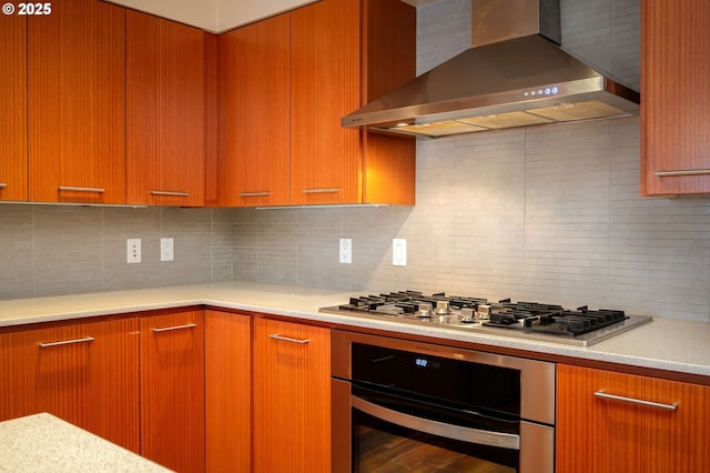 kitchen with hardwood / wood-style flooring, appliances with stainless steel finishes, wall chimney exhaust hood, and backsplash