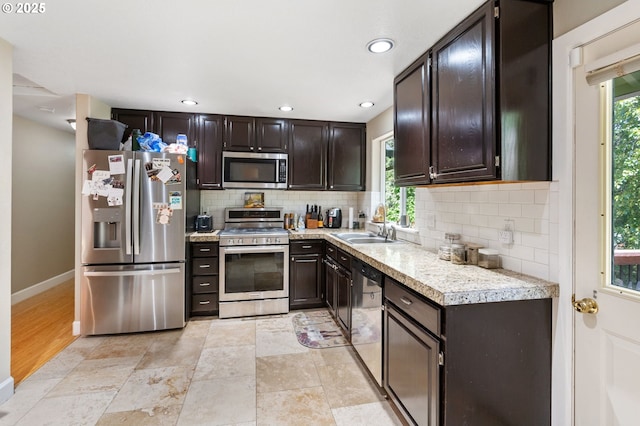 kitchen featuring dark brown cabinets, baseboards, light countertops, appliances with stainless steel finishes, and decorative backsplash